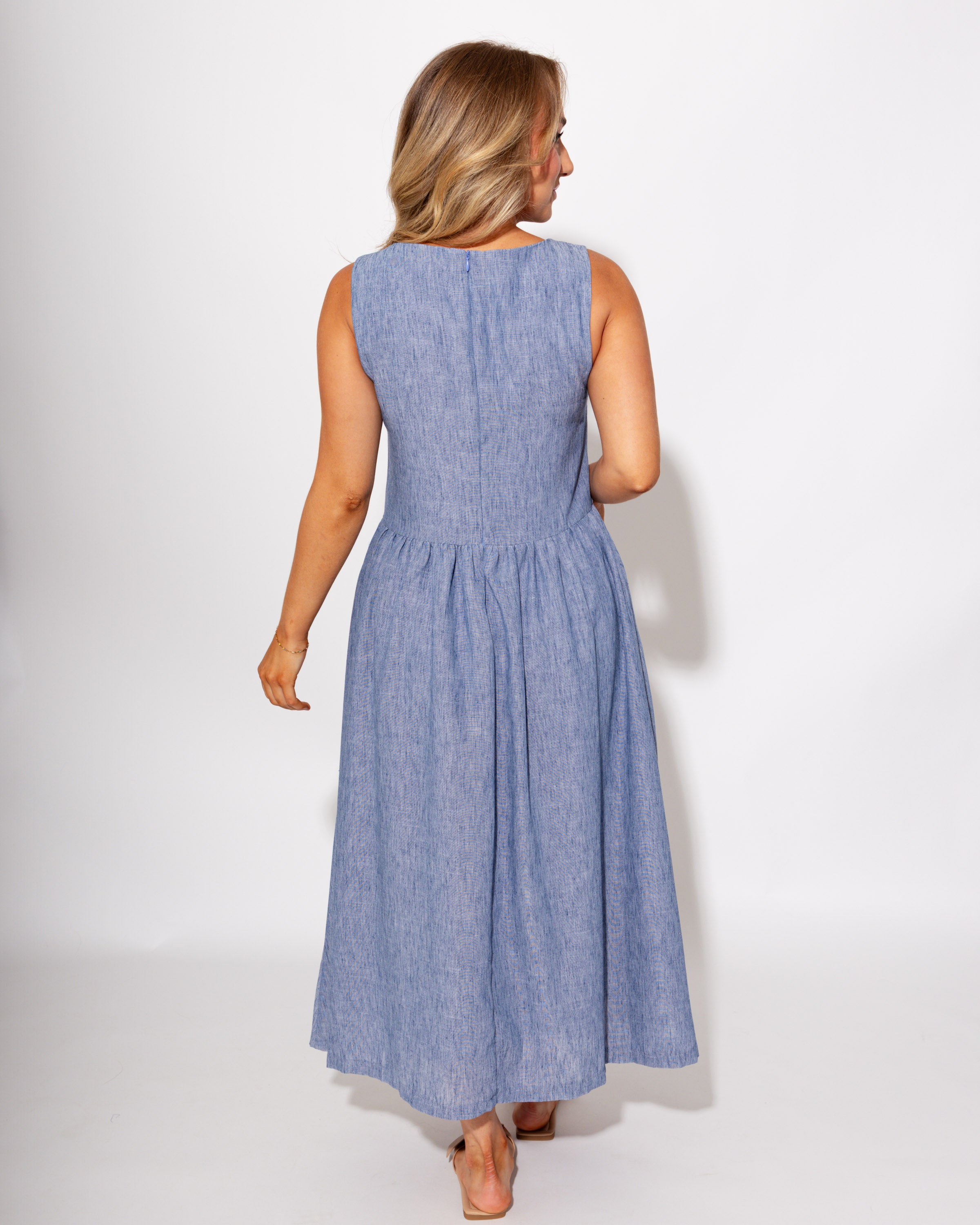 Light blue sleeveless pleated midi dress styled with sandals, summer outfit at Gaudie & Co
